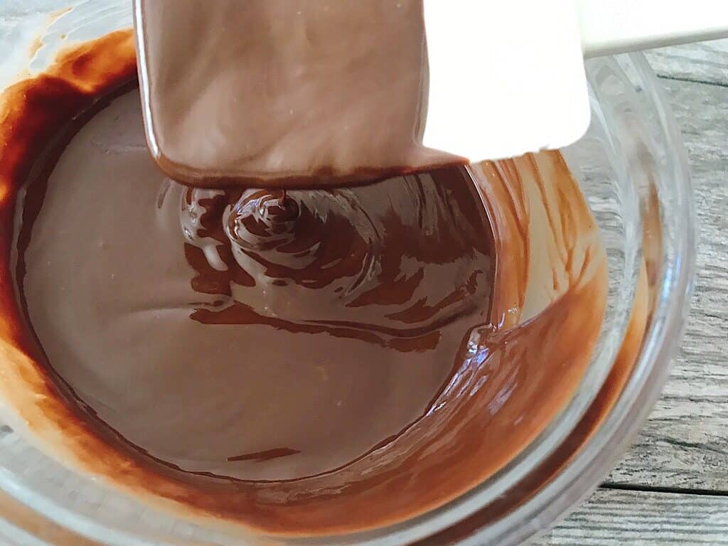 A spatula dripping with melted chocolate.