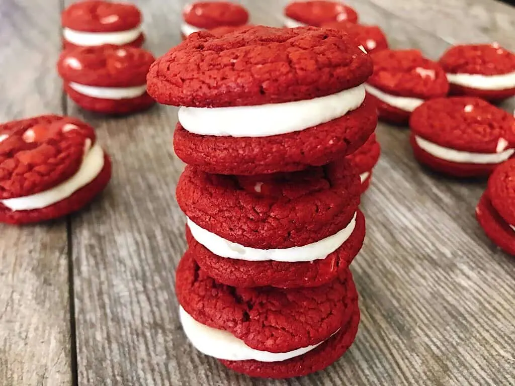 A stack of red velvet cake mix sandwich cookies with cream cheese frosting