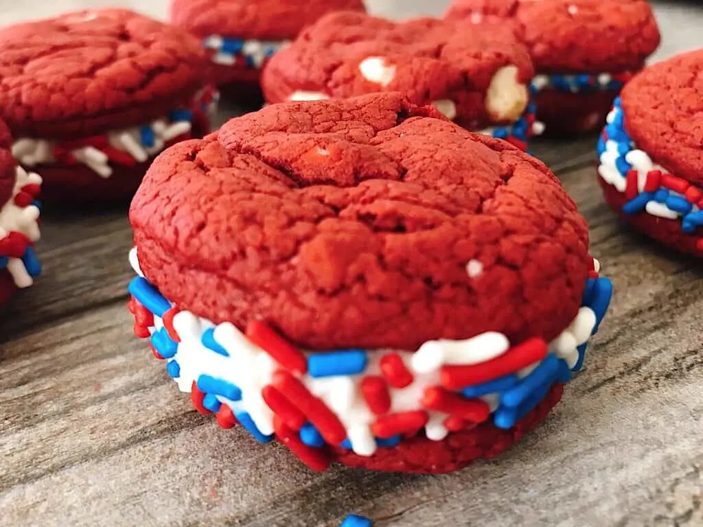 A red velvet cake mix sandwich cookie with red, white, and blue sprinkles.