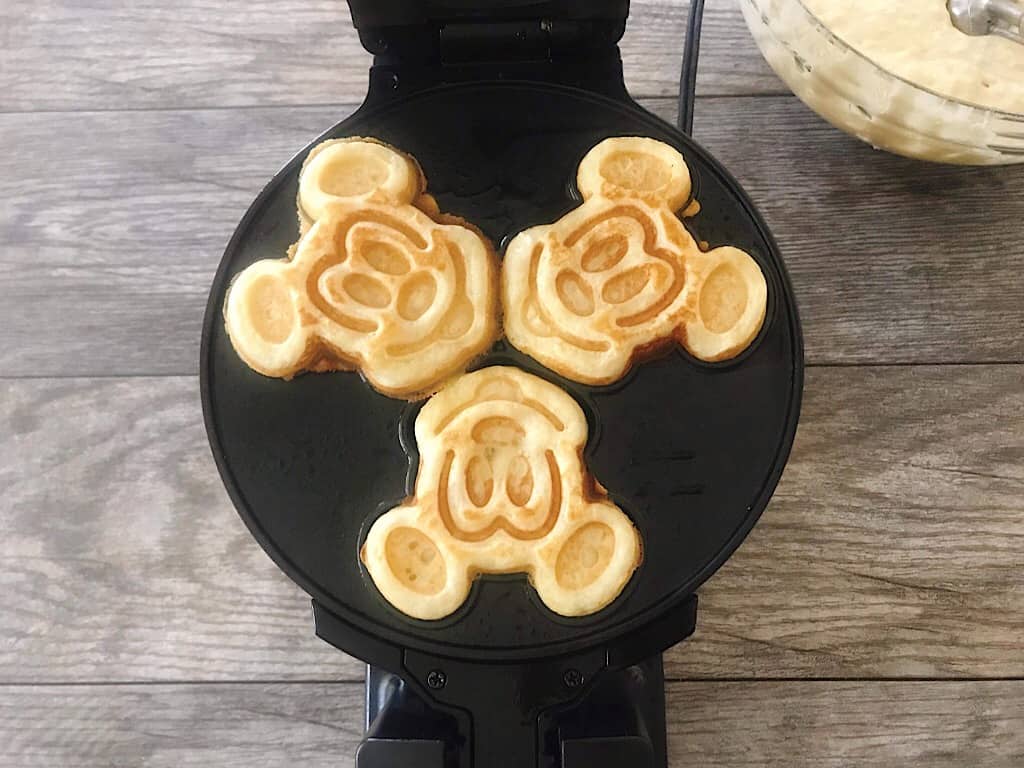 Knusprige Waffeln in einem Mickey-Mouse-Waffeleisen.