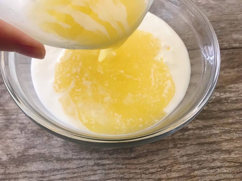 Geschmolzene Butter in eine Schüssel mit knusprigen Waffeln Teig gegossen.