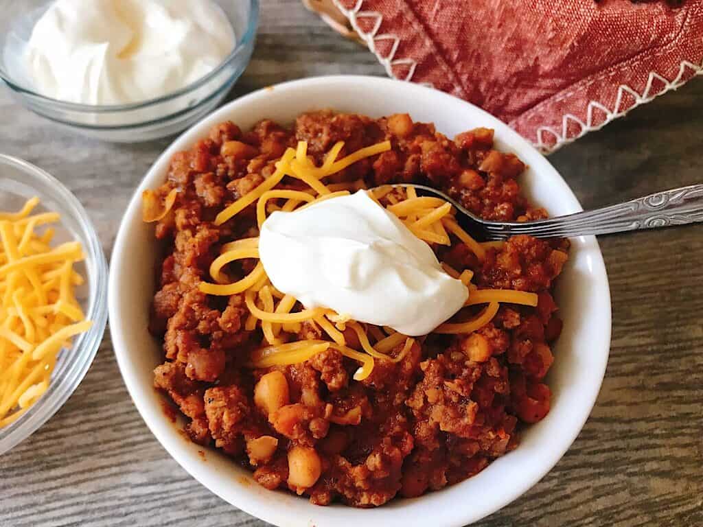 A bowl of buffalo chicken chili with cheese and sour cream