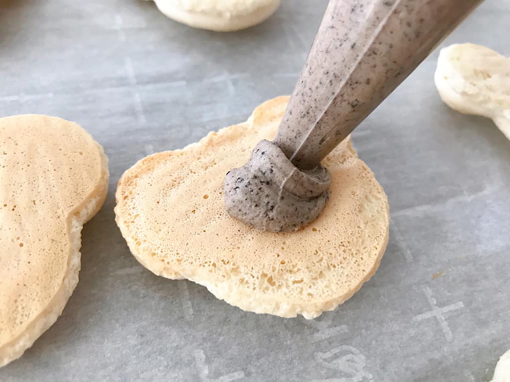 OREO filling piped onto a Mickey Macaron