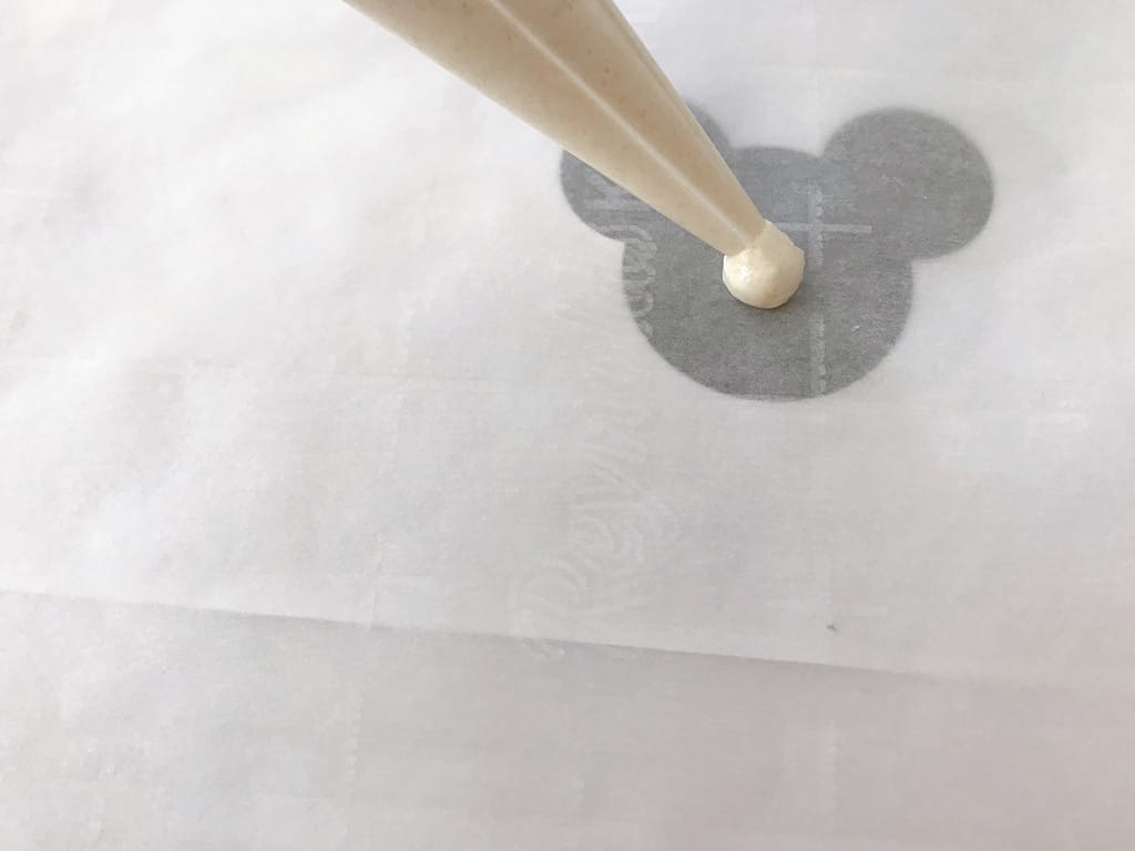 Macaron batter piped on parchment paper