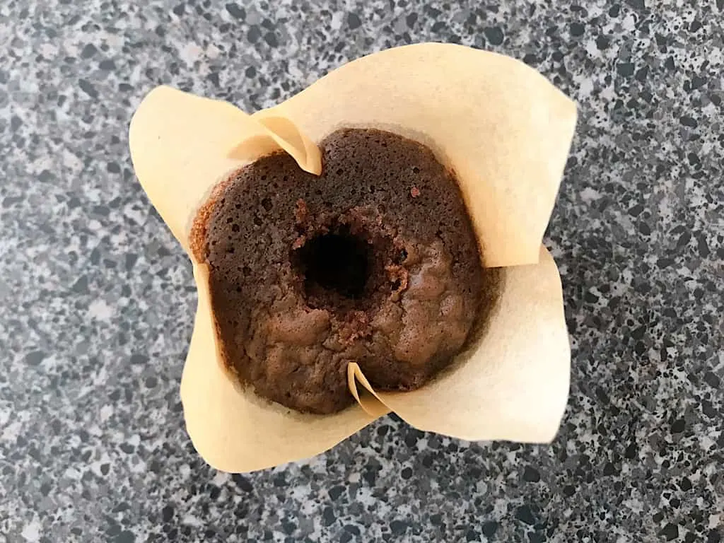 A chocolate cupcake with a hole in the middle.