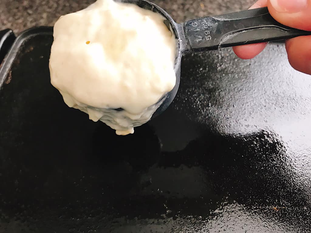 Best fluffy buttermilk pancake recipe batter in a measuring cup