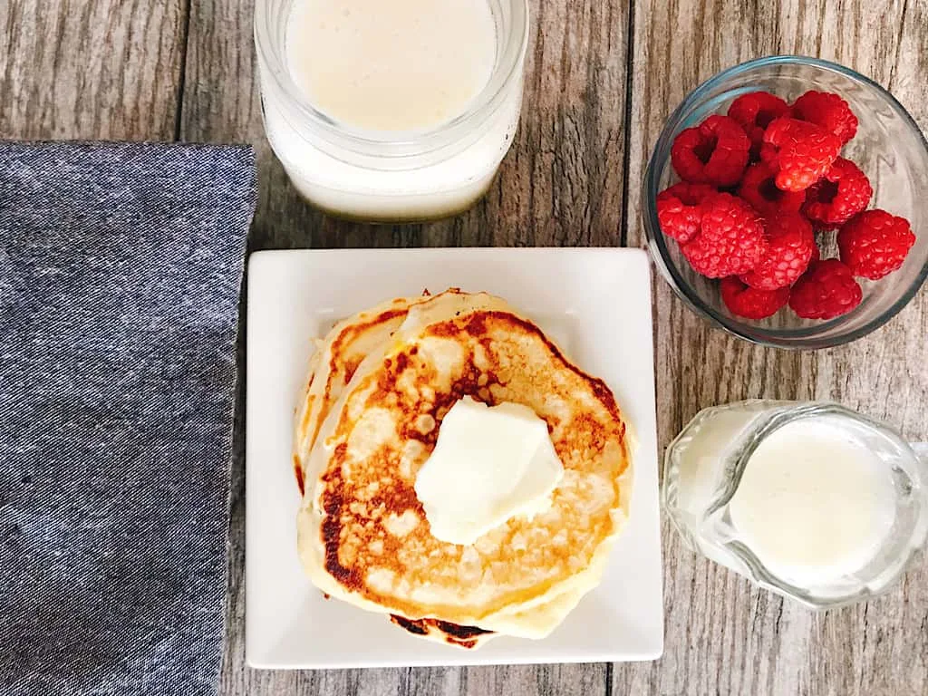 Buttermilk pancakes with syrup and raspberries