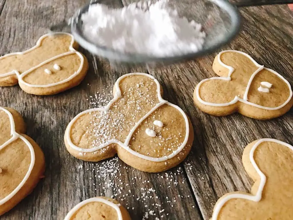 Powdered sugar dusted on Mickey Mouse shaped Gingerbread Sugar Cookies