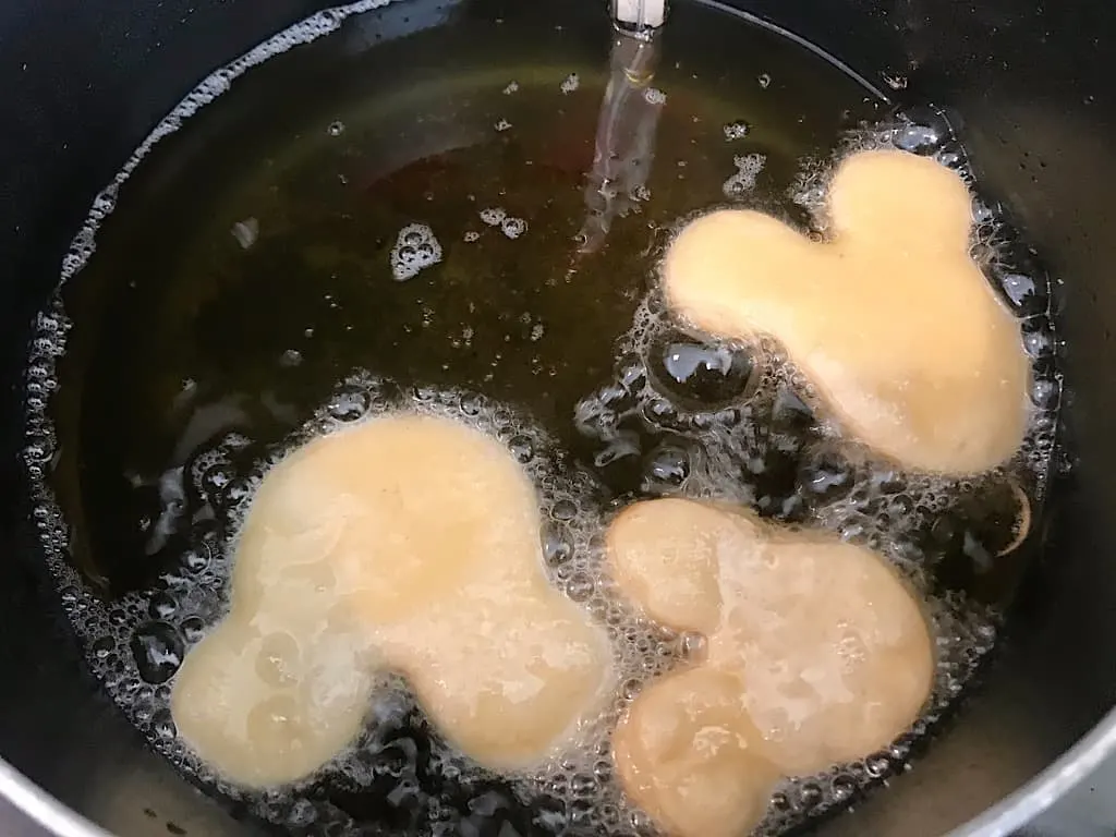 Mickey Beignets frying in a pan
