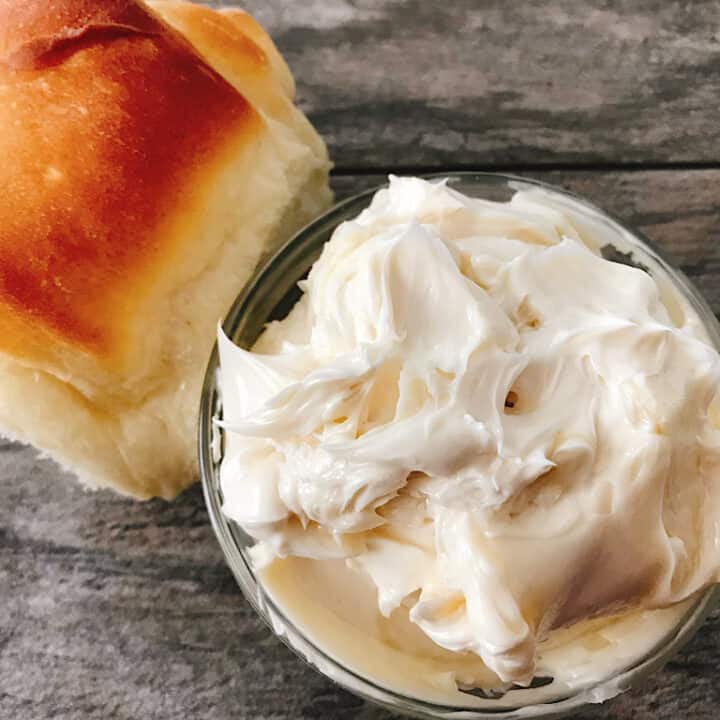 A Lion House roll and a bowl of whipped honey butter