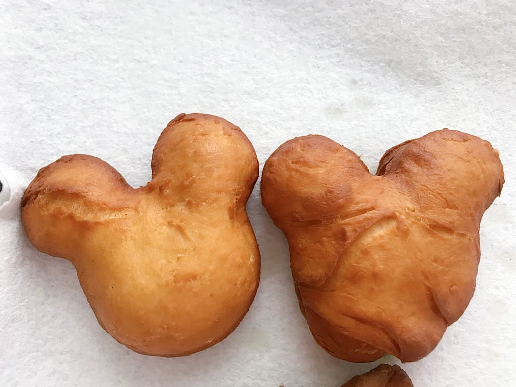 A Mickey Beignet and a bag of powdered sugar