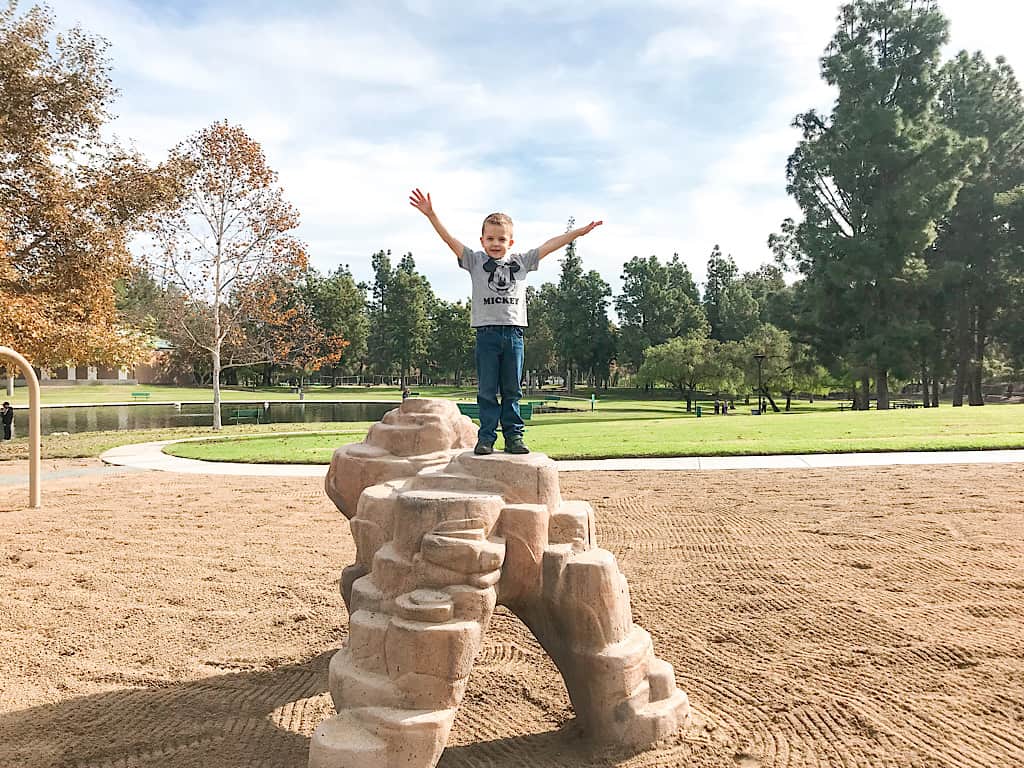 A boy on a toy arch atRalph B Clark Regional Park in Southern California