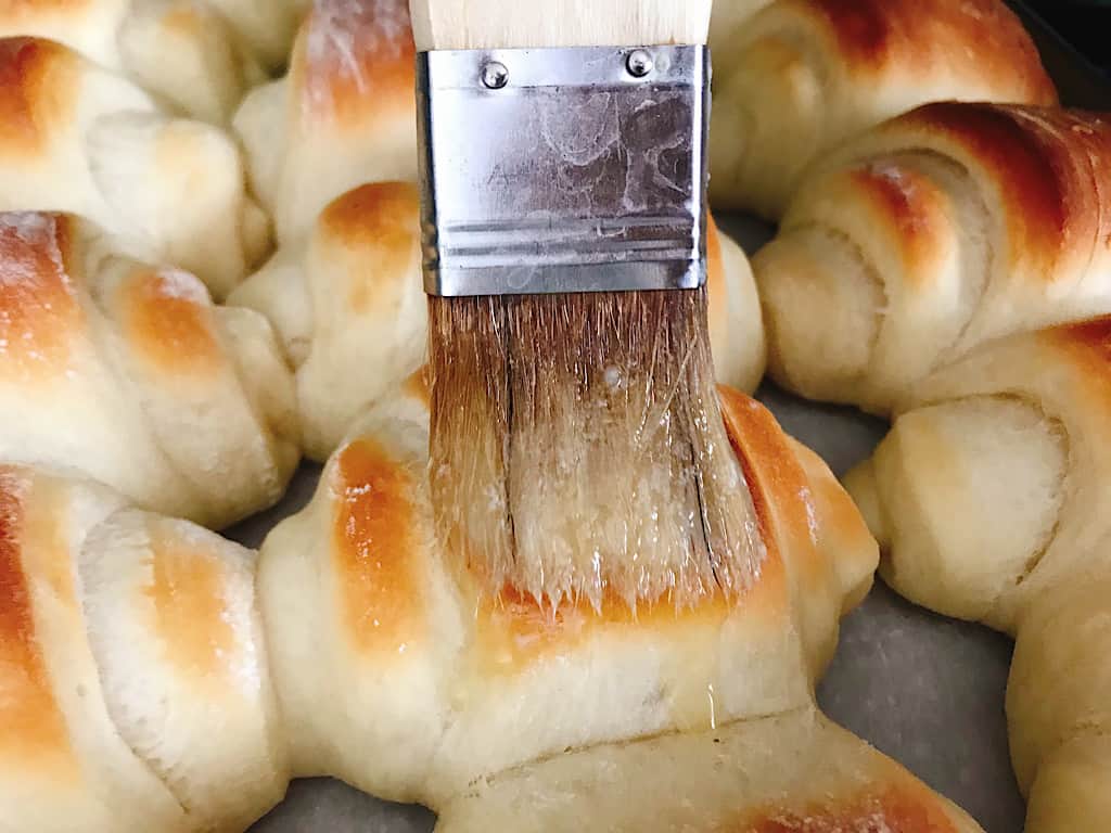 Melted butter brushed onto Lion House Rolls.