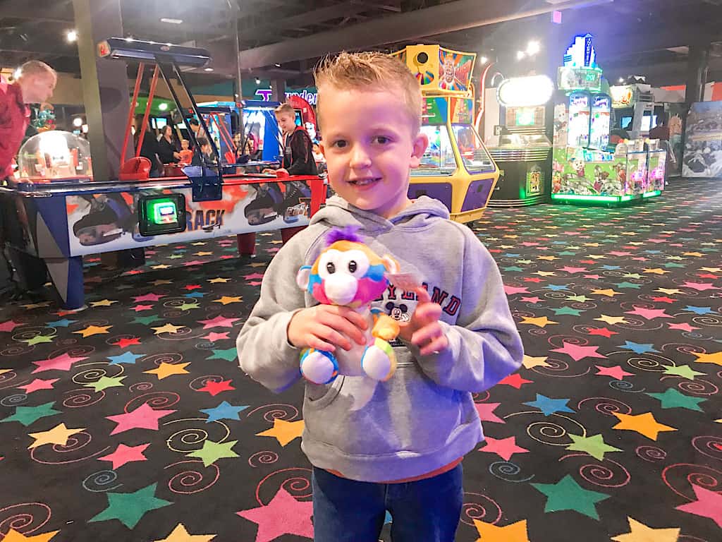 A boy with prizes he won at John's Incredible Pizza