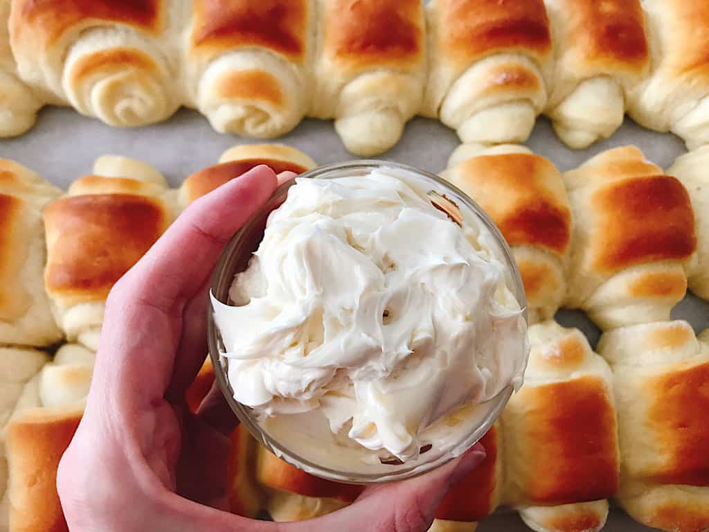 A bowl of whipped honey butter and Lion House Rolls