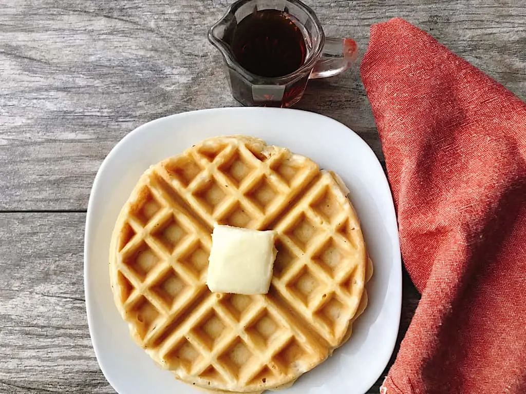 A waffle with butter and syrup