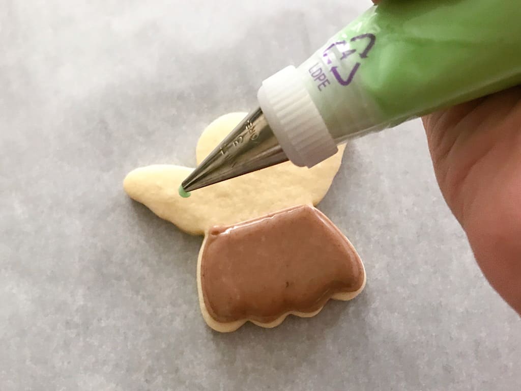 Green frosting in a piping bag for Baby Yoda Sugar Cookies