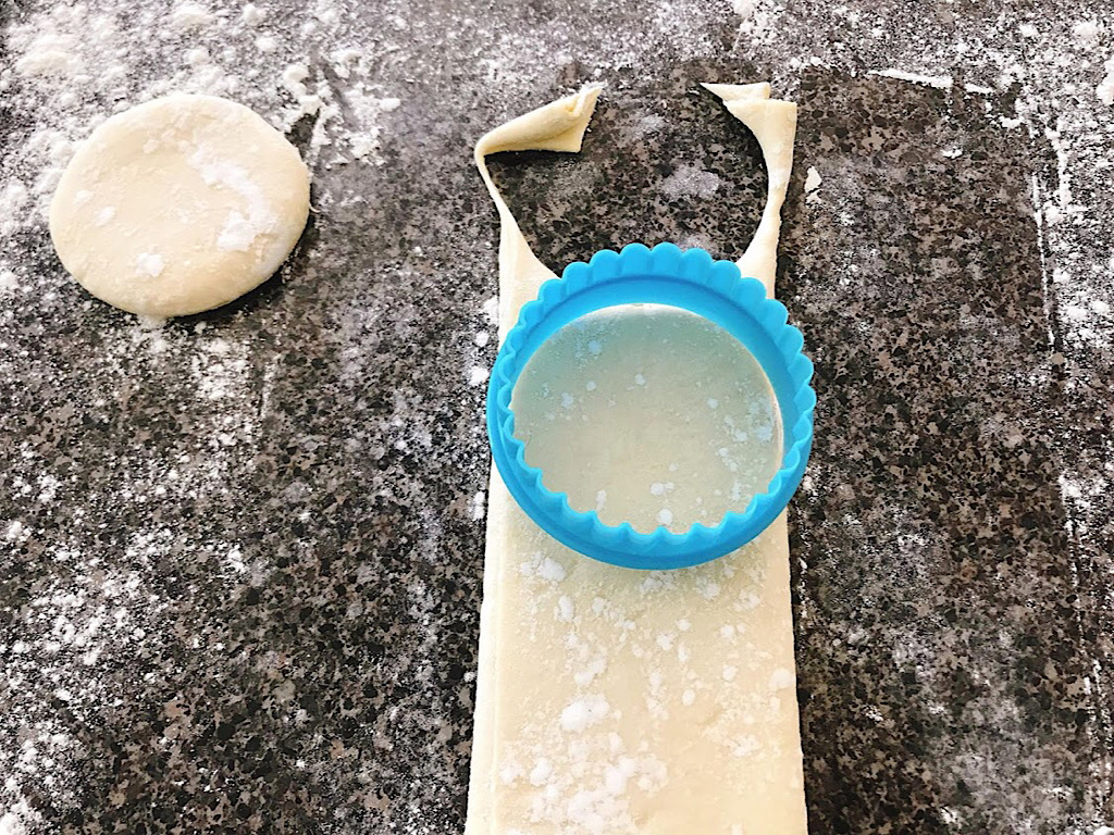 Circles being cut out of dough for Disney World Cronuts