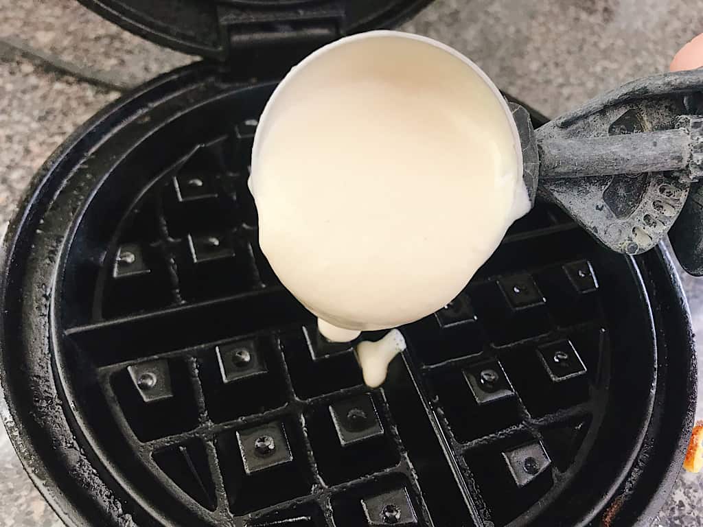 Easy waffle batter poured onto a waffle iron