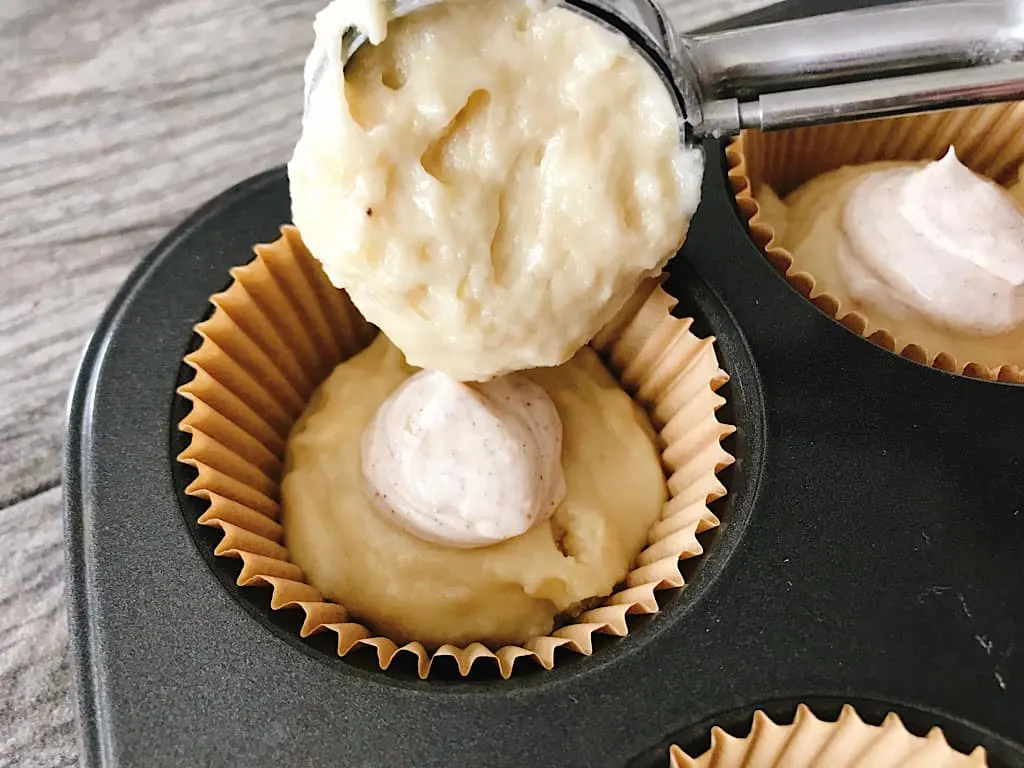 Banana muffin batter scooped into muffin liners