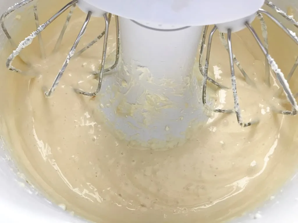 Cheesecake batter in a stand mixer to make strawberry cheesecake cupcakes