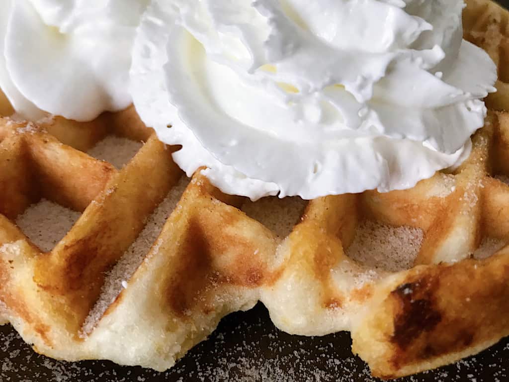 Close up picture of a funnel cake waffle and whipped cream