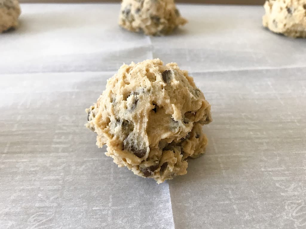 A ball of cookie dough on a baking sheet