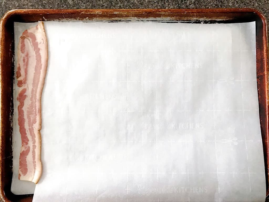 Bacon on a baking sheet with parchment paper