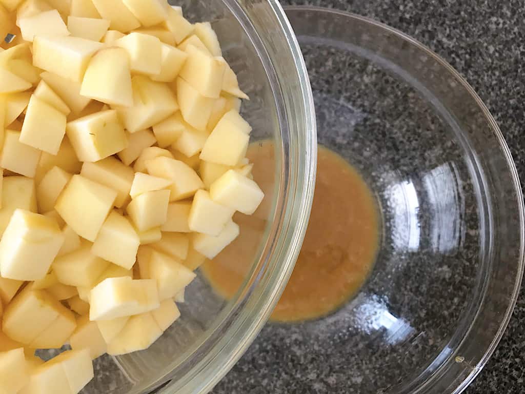 Diced apples and a bowl of caramel to make pie filling