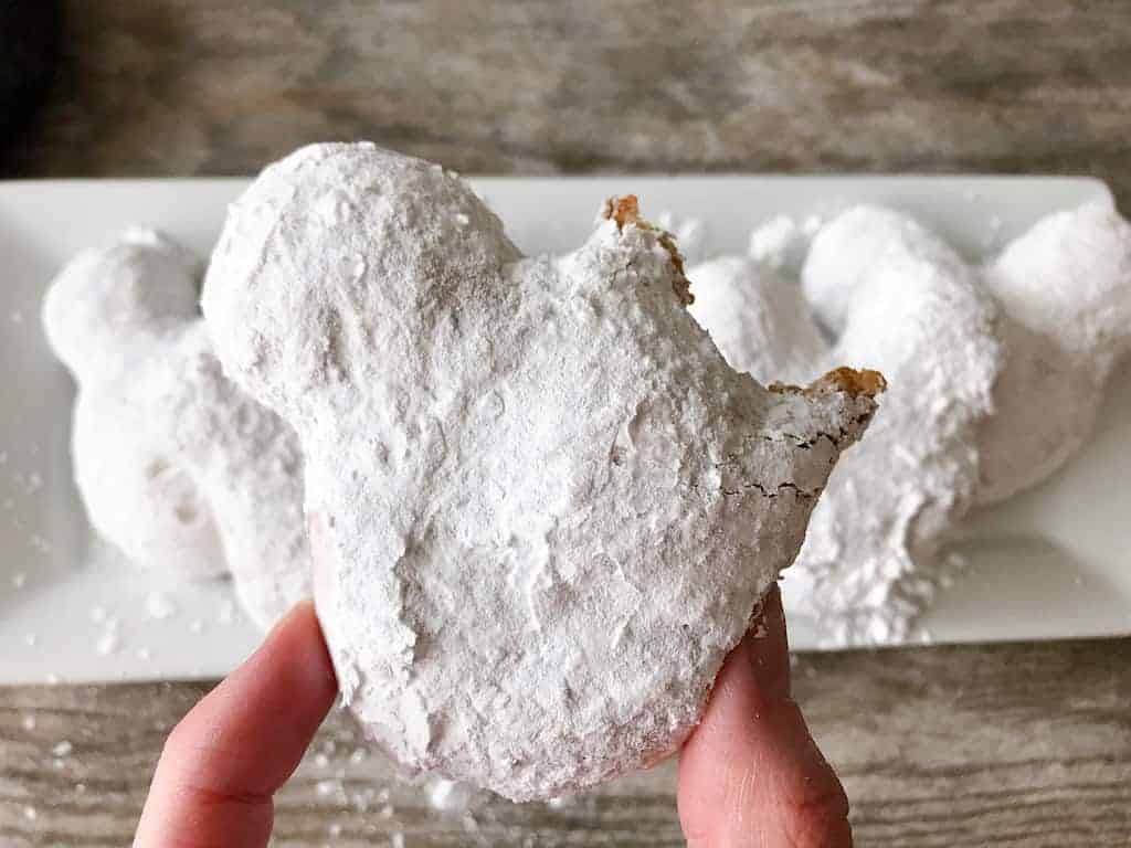 A Mickey Beignets made with pizza dough and covered in powdered sugar
