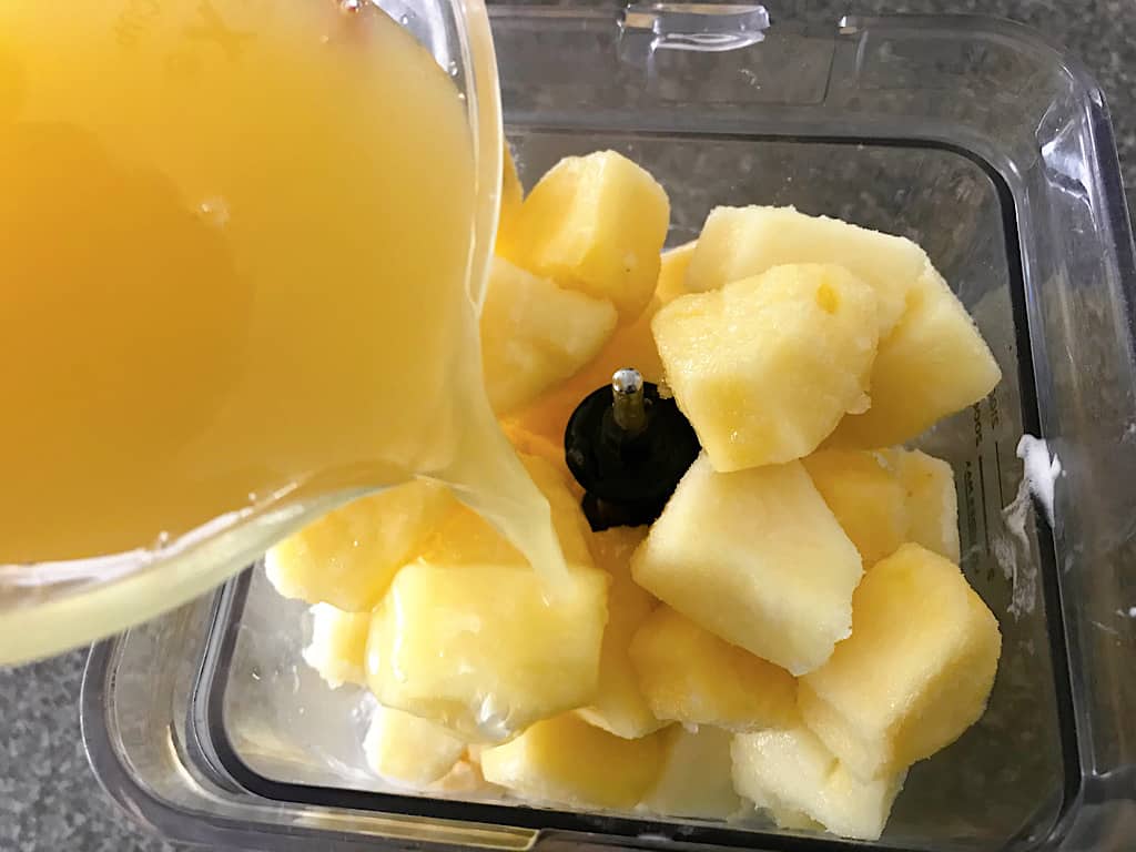 Pineapple juice in a blender to make homemade Dole Whip.