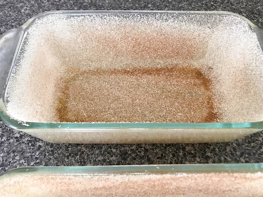 Mix together 1/2 cup of sugar and 2 teaspoons of cinnamon and sprinkle over the cooking spray in each loaf pan.