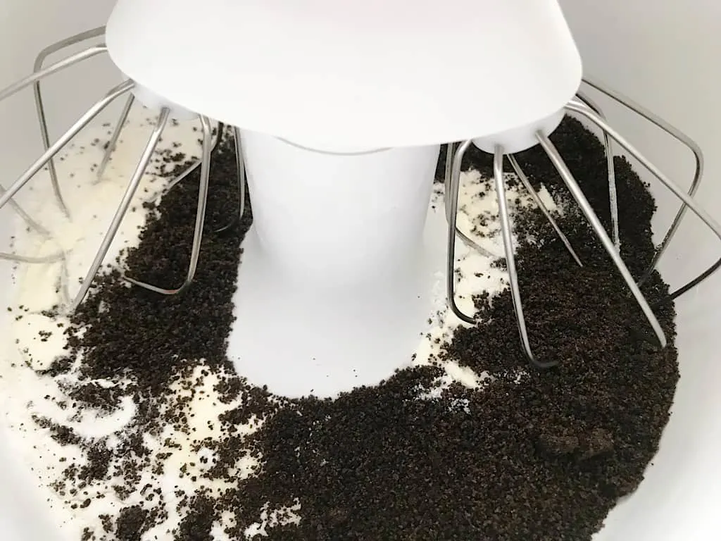 In the bowl of a stand mixer with a whisk attachment, add the heavy cream, white chocolate instant pudding, and OREO crumbs.