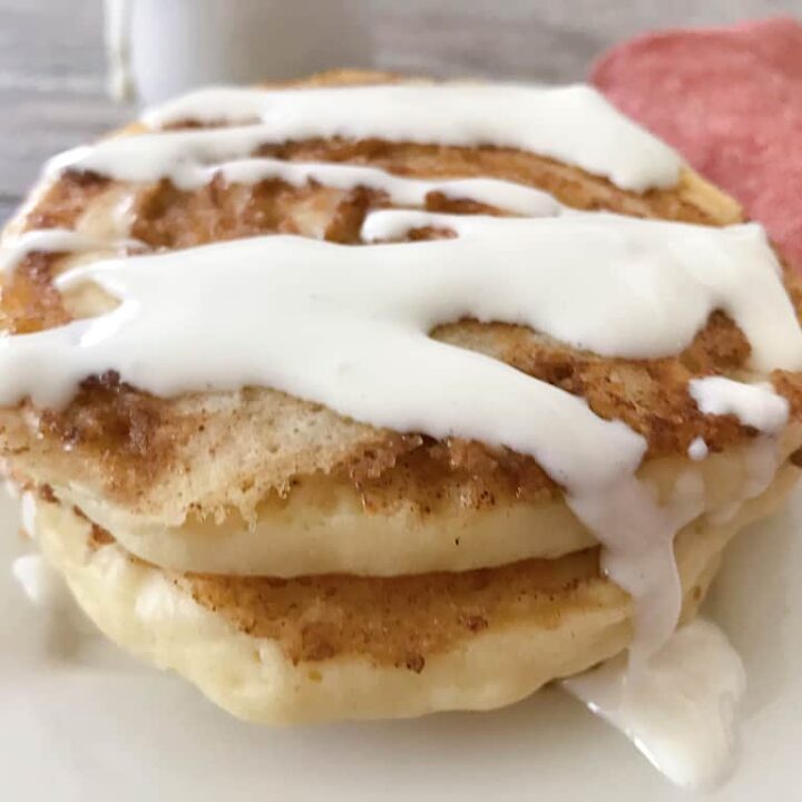 Cinnamon roll pancakes drizzled with cream cheese icing