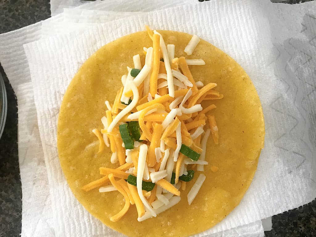 Add about 3-4 tablespoons of cheese to each tortilla, roll up and place in the baking dish.