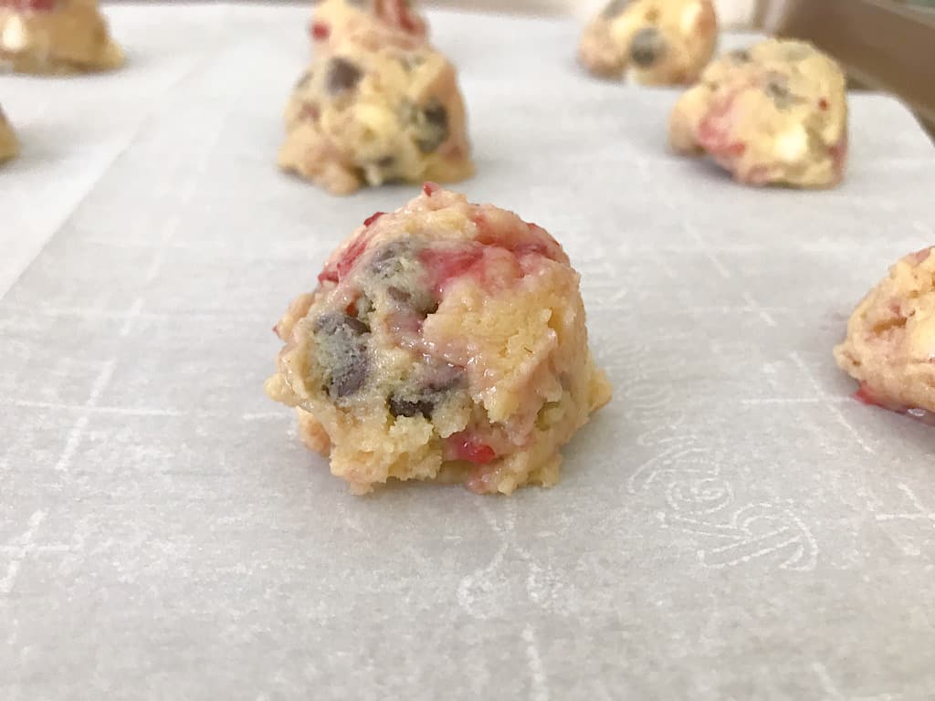 Place the dough on a baking sheet lined with parchment paper and press down on the center of the dough ball. Just enough that the cookie isn't totally round.