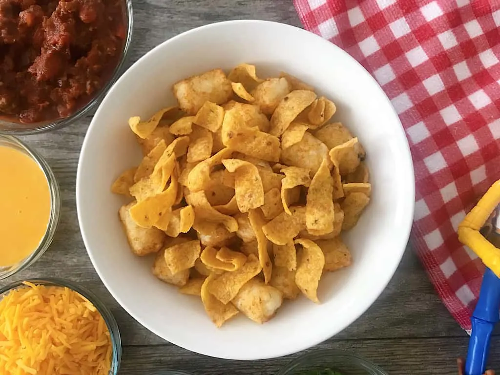 Divide the tater tots among 6 bowls and top the tater tots with Fritos.