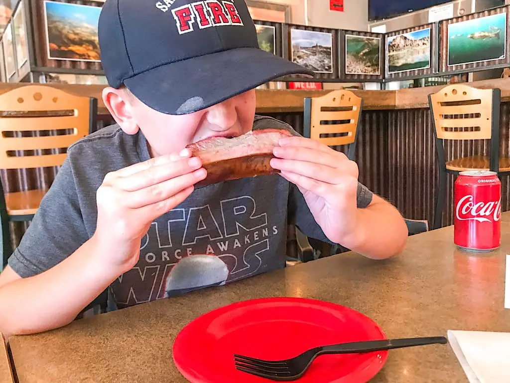 A boy eating ribs at Beartooth Barbecue in West Yellowstone, Montana