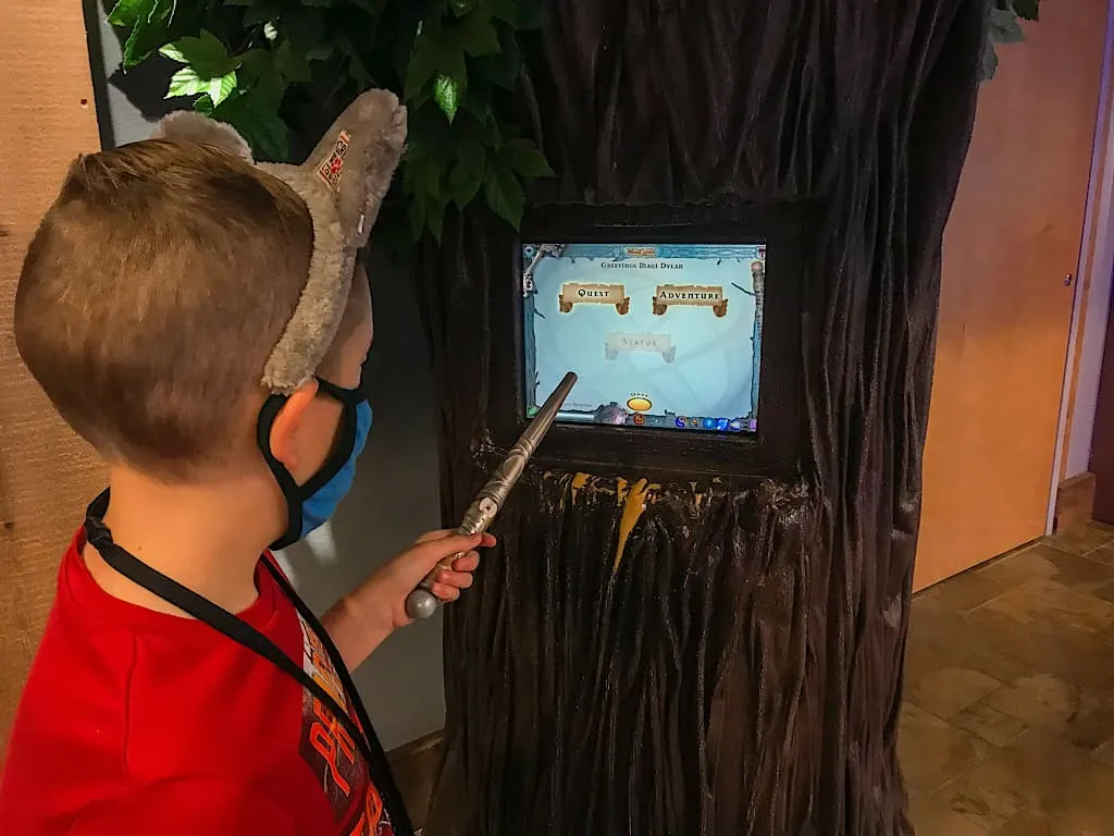 A child with Wolf Ears and a wand playing MagiQuest at Great Wolf Lodge
