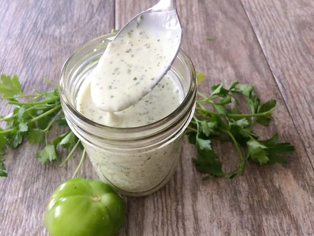A spoon and jar of tomatillo ranch