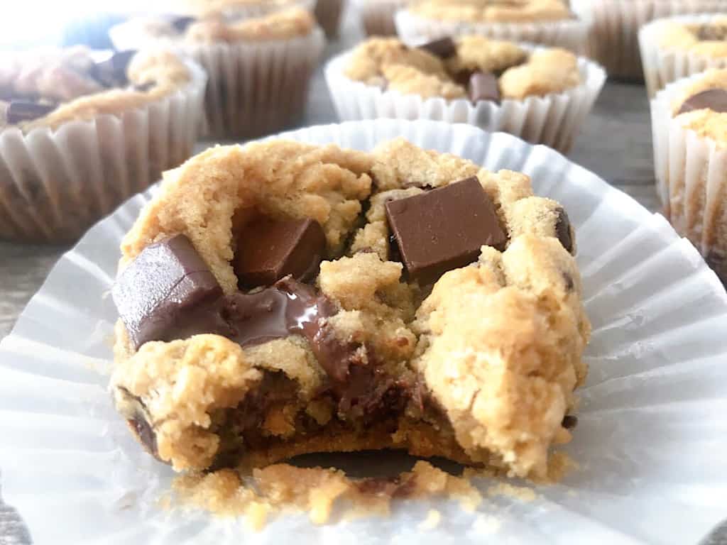 A close up of a deep dish chocolate chip cookie with chocolate chunks and a bite taken out.