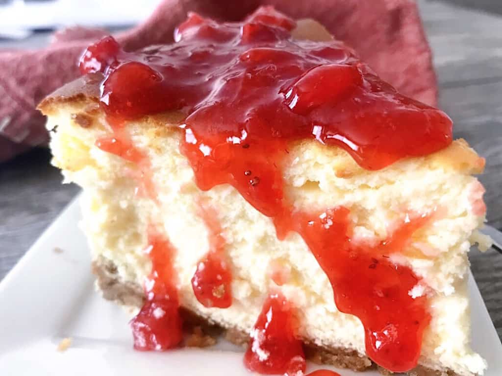 A slice of classic cheesecake with strawberry topping