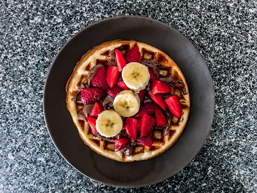 Top with Nutella, strawberries, and bananas.