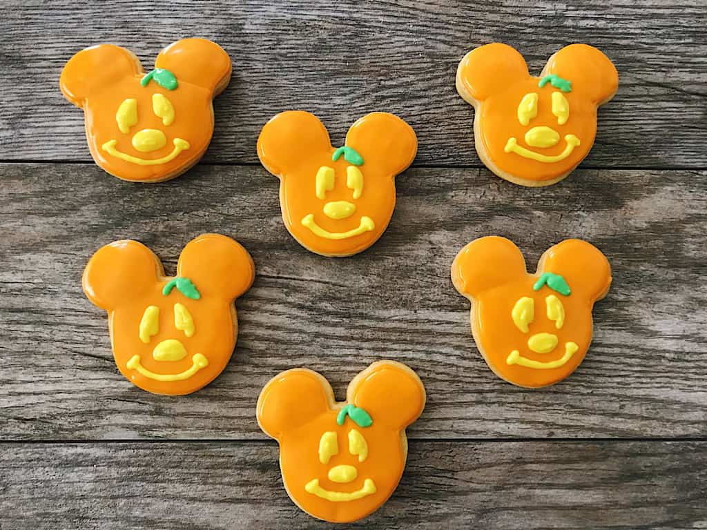Pumpkin Spice Sugar Cookies shaped like Mickey Mouse with orange frosting