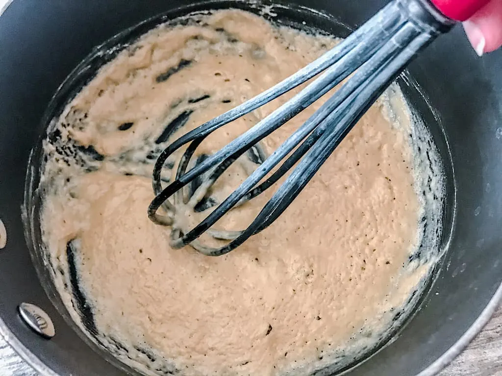 Sprinkle the flour over the butter and whisk to create a roux.