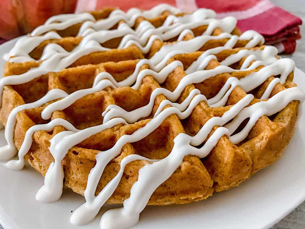 A Pumpkin spice waffle drizzled with cream cheese syrup