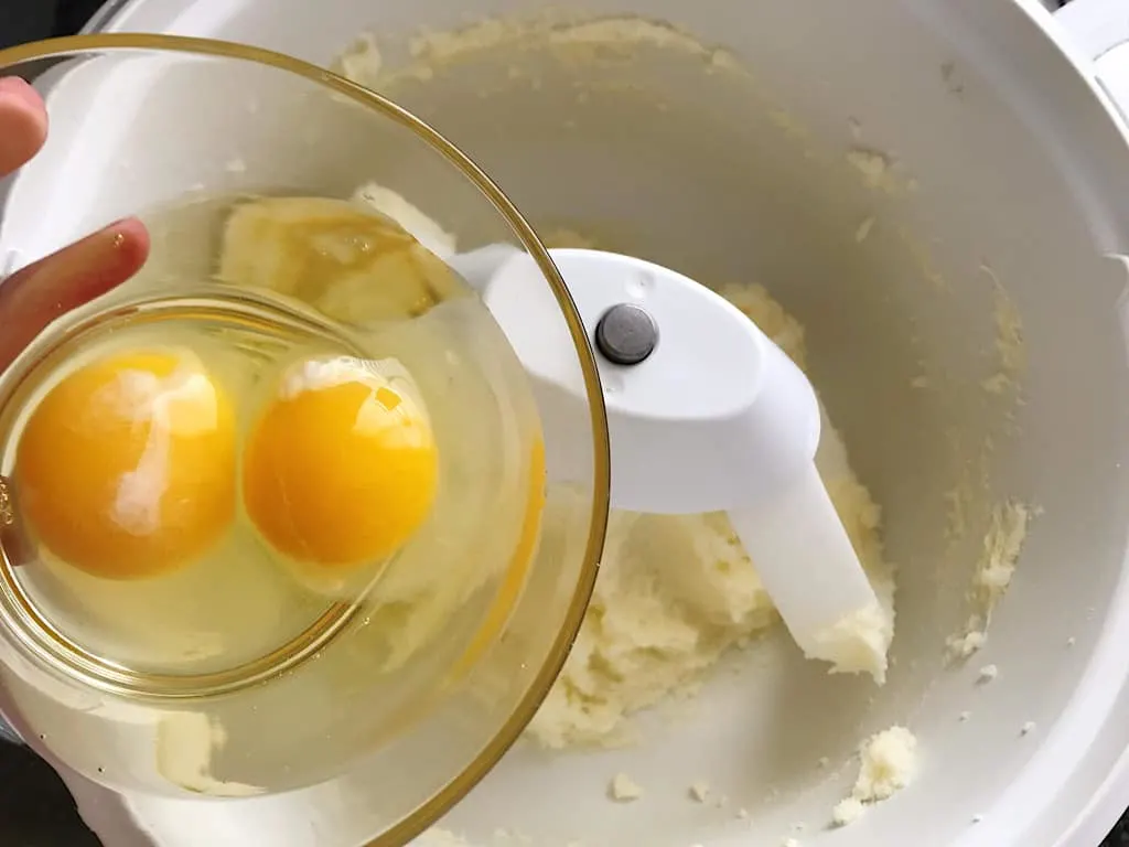 Eggs added to butter and sugar in an electric mixer