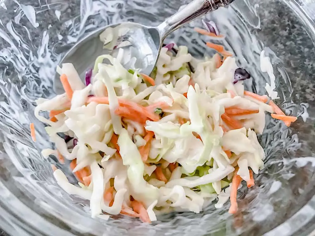 Place the cole slaw mix into a large bowl and add the dressing. Stir to coat.