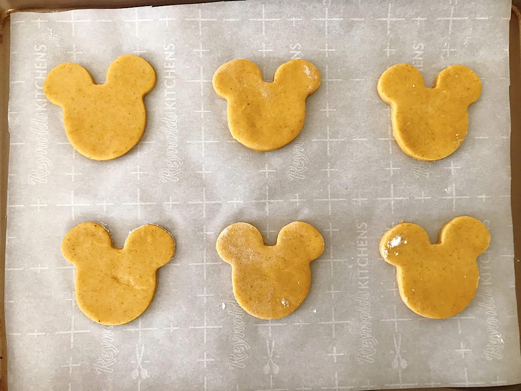 Mickey Mouse shaped pumpkin spice sugar cookies on a baking sheet