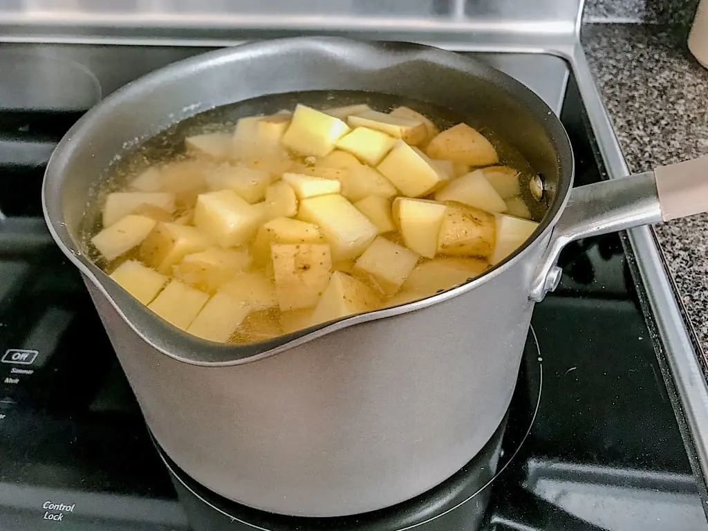 Potatoes boiling in a pan on a stove